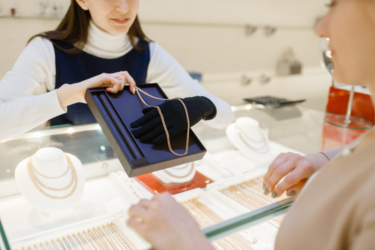 Mujer eligiendo cadena de oro en joyería