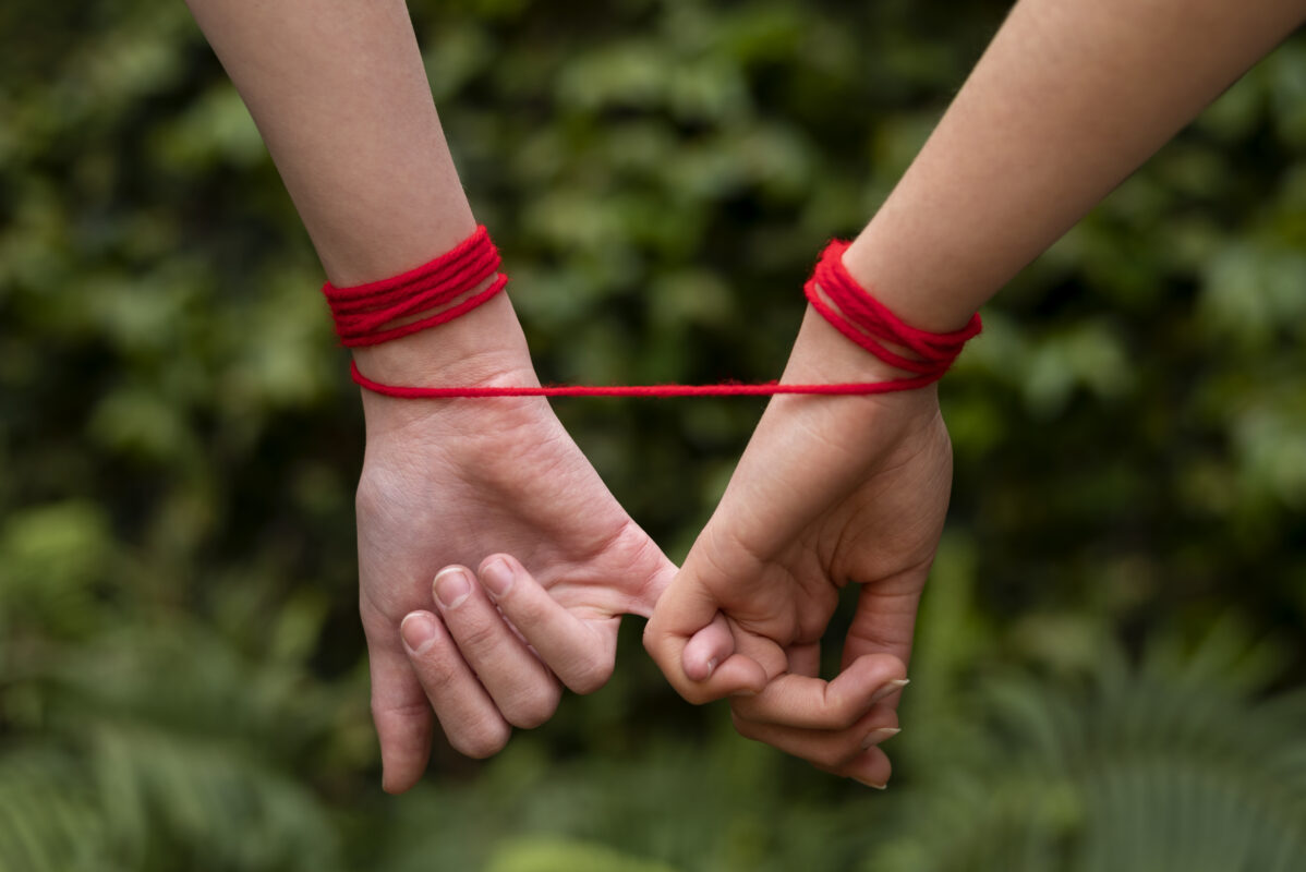 manos humanas conectadas con hilo rojo