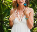 oven inocente, pura y hermosa mujer con vestido blanco, romántica, lírica, pensativa, naturaleza tropical verde, verano, relajada, tranquila, soñando, sosteniendo una flor, accesorios de moda